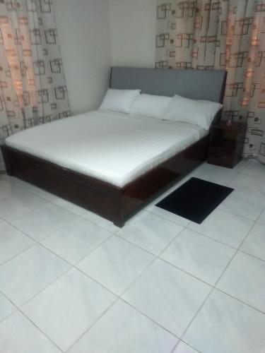 a bed in a room with a white floor at TwoSix24 Guest house in Kasi