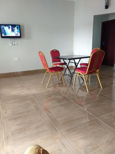 a table and four chairs in a room with a television at TwoSix24 Guest house in Kasi
