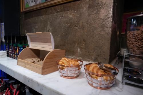 two baskets of bread and a box on a counter at Hotel Forty One in Bucharest