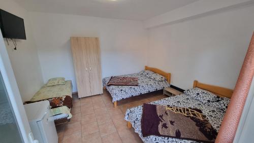 a small room with three beds and a television at Casa Mititelu in Costinesti