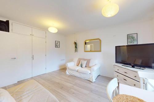 a living room with a television and a white couch at Modern 1 BD Apartment in London - 5 min to Station in London