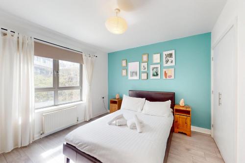 a bedroom with a bed and a blue wall at Modern 1 BD Apartment in London - 5 min to Station in London