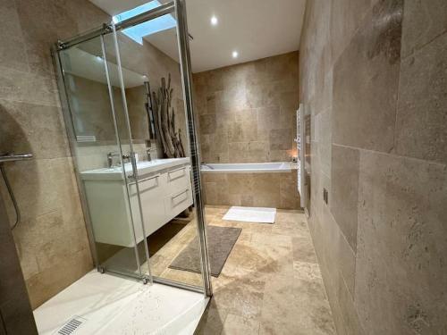 La salle de bains est pourvue d'une douche, d'un lavabo et d'une baignoire. dans l'établissement Le Nid d'Ars, à Ars-en-Ré