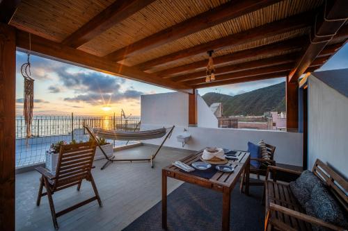 a balcony with a hammock and a table and chairs at Casa Norma in Lipari