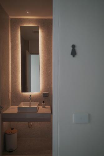 a bathroom with a sink and a mirror at Matini Hostel grandstation in Bang Su
