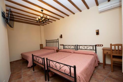 1 Schlafzimmer mit 2 Betten und einem Tisch in der Unterkunft POSADA LEPANTO in Socuéllamos