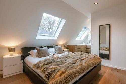 ein Schlafzimmer mit einem großen Bett mit einer Pelzmütze in der Unterkunft Luxurious apartment with parking in Beernem