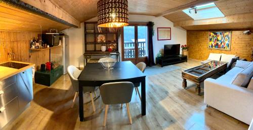 een keuken en een woonkamer met een tafel en stoelen bij Le Tremplin 61 in Barcelonnette