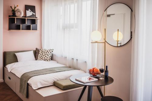 um pequeno quarto com uma cama e uma mesa em The Circus Living em Berlim
