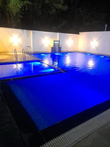 a large swimming pool with blue lighting at night at The King Palace and Resort in Udaipur