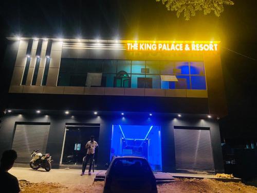 Ein Mann steht vor einem Gebäude mit blauem Licht. in der Unterkunft The King Palace and Resort in Udaipur