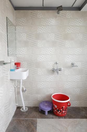 ein Badezimmer mit einem Waschbecken und einem Eimer in der Unterkunft Hotel Karan International ,Aurangabad in Aurangabad
