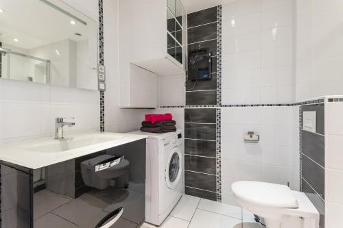 baño blanco con lavadora y lavamanos en PINK port nature coursive naturiste, en Cap d'Agde