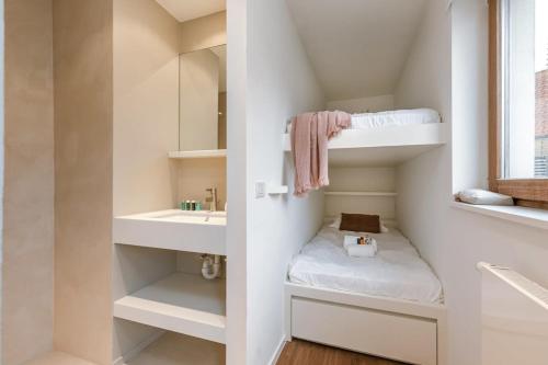 uma pequena casa de banho com um beliche e um lavatório em Modern renovated apartment with terrace and parking em Knokke-Heist