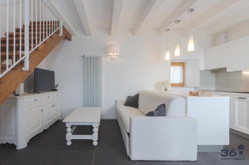 a white living room with a couch and a table at Trieste 10min dal Centro Villa Privata con Jacuzzi in Trieste