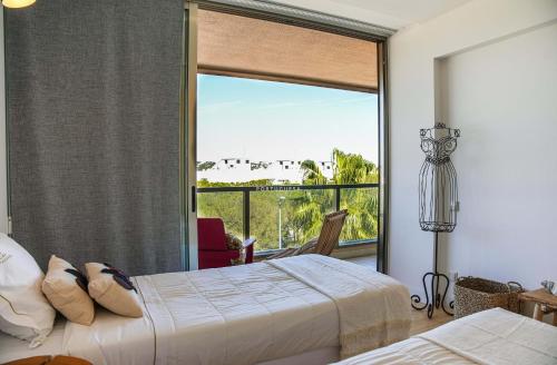 um quarto com duas camas e uma janela grande em Apartment Terracota By Dalma Portuguesa na Galé