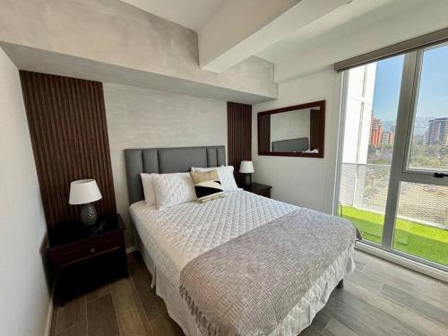 a bedroom with a bed and a large window at Apartment with perfect city view in Guatemala