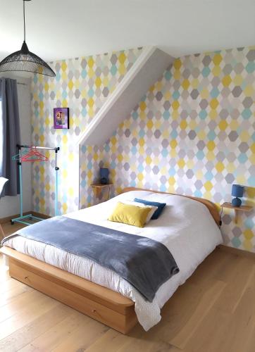 1 dormitorio con 1 cama grande con almohadas amarillas en La Cotentine, en Coutances