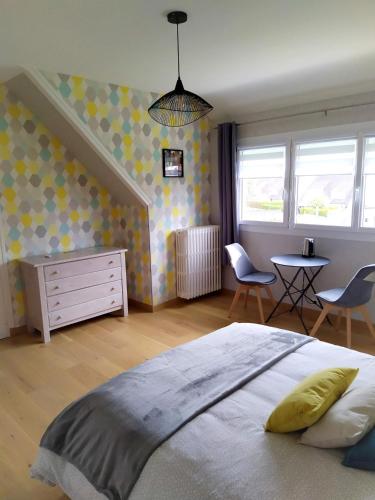 1 dormitorio con 1 cama, mesa y sillas en La Cotentine, en Coutances