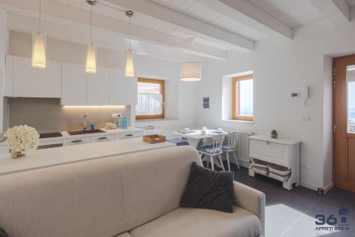 a living room and kitchen with a couch and a table at Trieste 10min dal Centro Villa Privata con Jacuzzi in Trieste