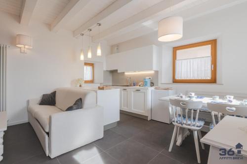 a kitchen and living room with a couch and a table at Trieste 10min dal Centro Villa Privata con Jacuzzi in Trieste