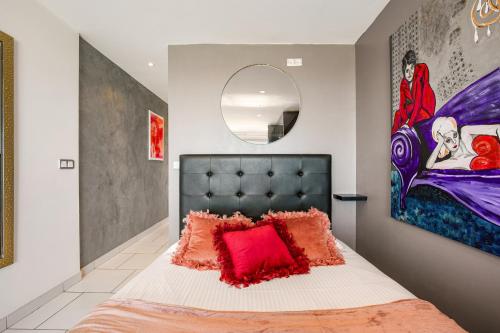 Un dormitorio con una cama grande con una almohada roja. en PINK port nature coursive naturiste, en Cap d'Agde