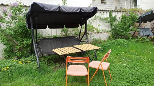a picnic table with two chairs and a table with a tent at Willa Retro Hostel in Krakow
