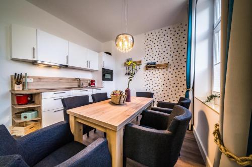 uma cozinha com uma mesa de madeira e cadeiras em RIAS-Beachvilla-Ocean em Borkum