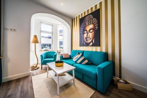 uma sala de estar com um sofá azul e uma mesa em RIAS-Beachvilla-Ocean em Borkum