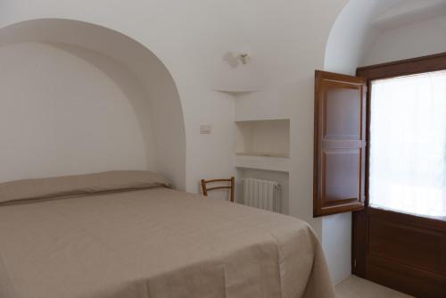 - une chambre avec un lit et une fenêtre dans l'établissement Trulli della Tranquillità, à Ostuni