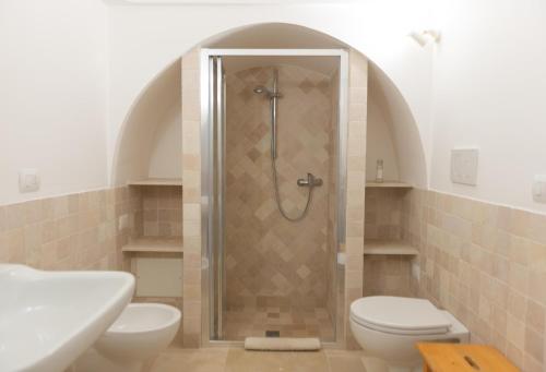 La salle de bains est pourvue d'une douche, de toilettes et d'un lavabo. dans l'établissement Trulli della Tranquillità, à Ostuni