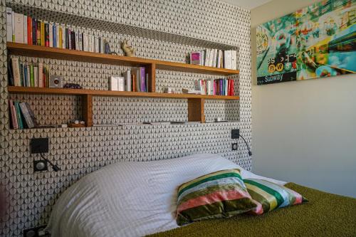 - une chambre avec un lit et des étagères murales dans l'établissement Le 8 république climatisé parking gratuit, à Colmar