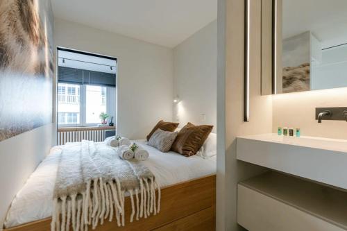 Dormitorio pequeño con cama y lavamanos en Cosy studio in centre of Knokke, en Knokke-Heist