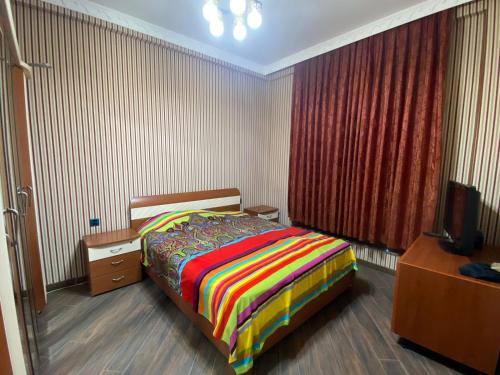 a bedroom with a bed and a dresser and a television at Rezidens CASPIAN LINE in Buzovna
