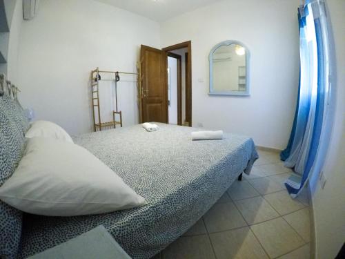a bedroom with a bed with two pillows and a mirror at Strategic Home in Platamona