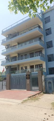um edifício de apartamentos com uma cerca em frente em RidgeWay Stay em Faridabad