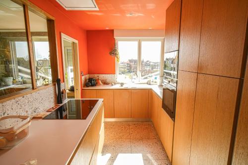 une cuisine orange avec un évier et une fenêtre dans l'établissement Le 8 république climatisé parking gratuit, à Colmar