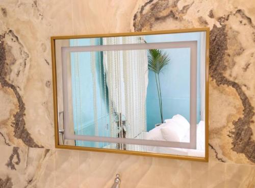 a mirror on a wall with a palm tree at Foga Hebrus in Ksamil