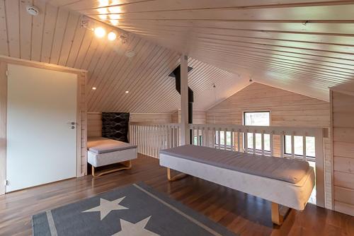 1 dormitorio con 1 cama en una casa de madera en Villa Luoteistuuli - 8+2 hlö, Luoteis-Himos Ski-in/out, 88m² + 30m², en Jämsä