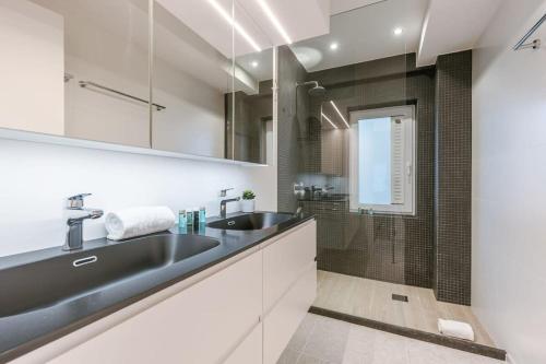 y baño con lavabo y ducha. en Spacious apartment with parking on prime location, en Knokke-Heist