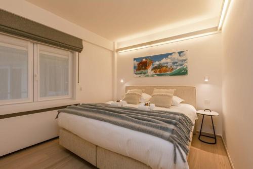 Un dormitorio con una cama grande y una ventana en Spacious apartment with parking on prime location, en Knokke-Heist