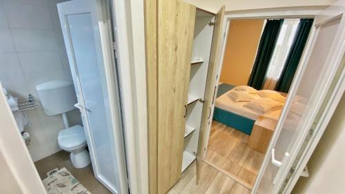 a small room with a toilet and a bedroom at Hotel Decebal Estival Neptun in Neptun