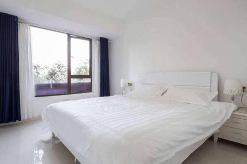 a white bedroom with a large bed and a window at 漂亮的卧室 元朗01 in Hong Kong