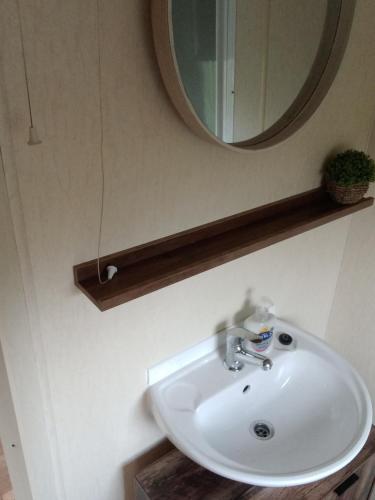 a white sink in a bathroom with a mirror at SANDY BAY STAYOVER in North Seaton