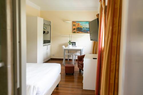 ジェノヴァにあるレックス ホテル レジデンスのベッドとテーブル付きの小さな部屋