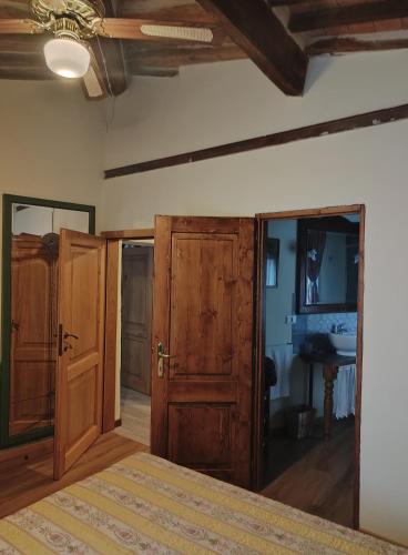a bedroom with a bed and wooden doors at La Spelonca degli Asini in Prata