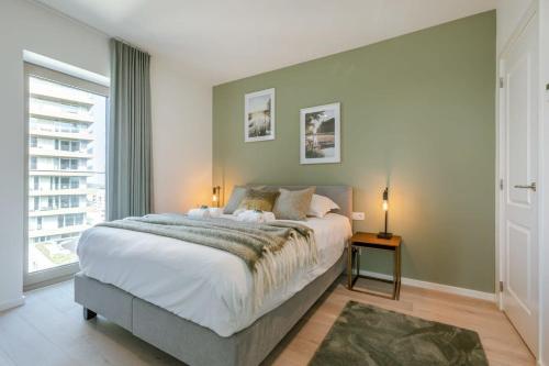 Un dormitorio con una cama grande y una ventana en Apartment with beautiful seaview in Ostend, en Ostende
