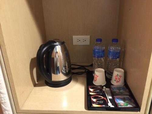 una cafetera y dos botellas de agua en un estante en Banciaoking Hotel, en Taipéi