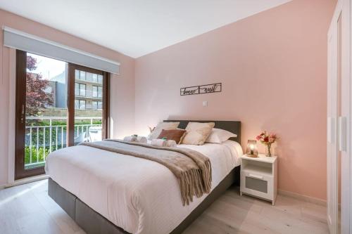 a white bedroom with a large bed and a window at Beachfront apartment in Zeebrugge in Bruges
