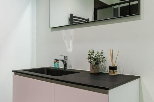 a black sink in a bathroom with a mirror at Beachfront apartment in Zeebrugge in Bruges